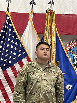Rodolfo Antonio Paulino Hernandez standing in front of flags